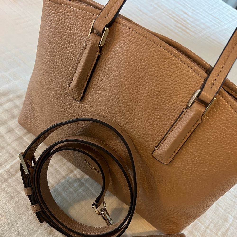 Kate Spade satchel with crossbody strap between a cream and tan color